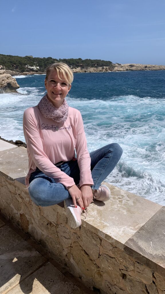 Melanie auf der Mauer an einer Mittelmeerküste